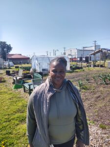 Renee Foster with her urban farm and high tunnel in background
