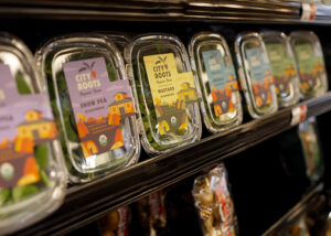 A grocery store shelf displaying packaged farm produce.